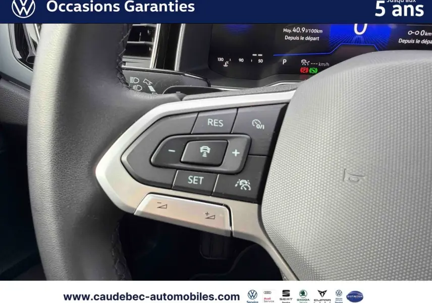 Gros plan sur le volant multifonctions noir de la Volkswagen Polo 2025 avec commandes de régulateur de vitesse.