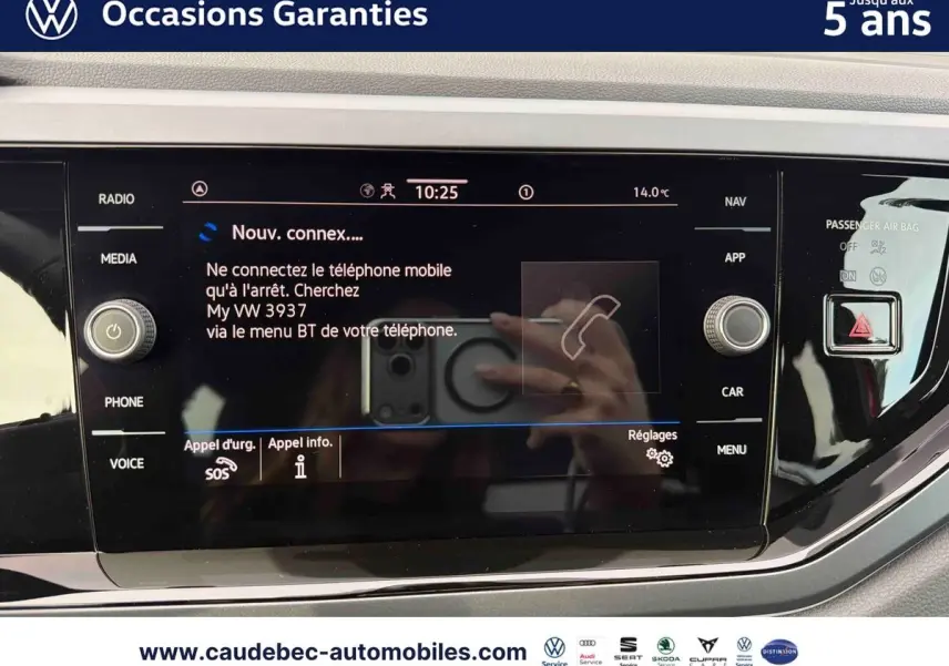 Vue rapprochée de l’écran tactile multimédia noir du Volkswagen Polo rouge, affichant la connexion Bluetooth active.