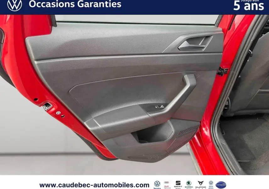 Vue rapprochée de la porte arrière gauche rouge du Volkswagen Polo 2025 avec intérieur noir et commande de fenêtre.