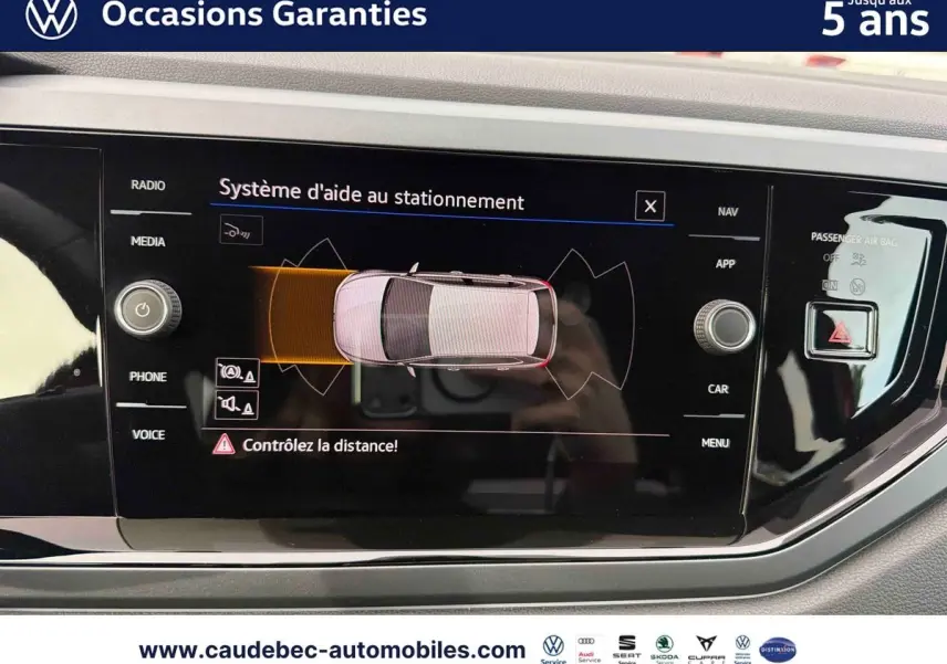 Écran tactile intérieur de la Volkswagen Polo rouge montrant le système d'aide au stationnement en vue du dessus.