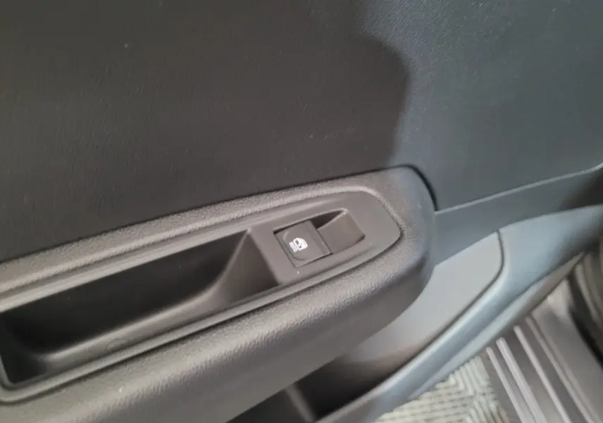 Gros plan sur la commande de lève-vitre côté conducteur de la Renault Clio gris foncé Evolution Blue dCi 100 2025.