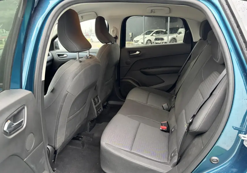 Vue intérieure arrière côté gauche du Renault Arkana bleu Zanzibar, sièges tissu gris et portières sombres.