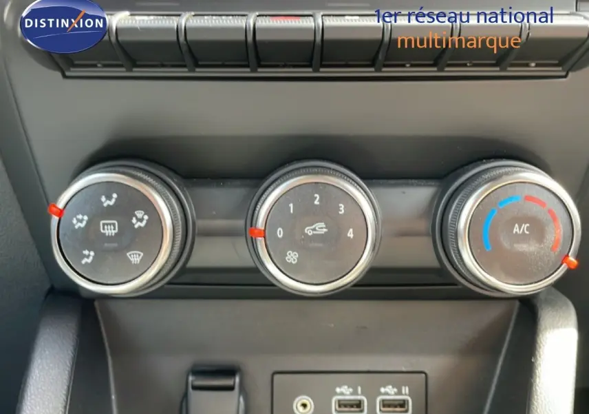 Gros plan sur les commandes de climatisation et les ports USB de la Renault Clio gris schiste, intérieur noir.