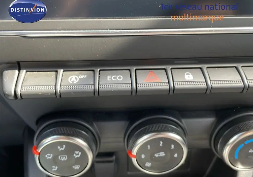 Gros plan sur les commandes de climatisation et boutons fonctionnels du tableau de bord de la Renault Clio gris schiste.