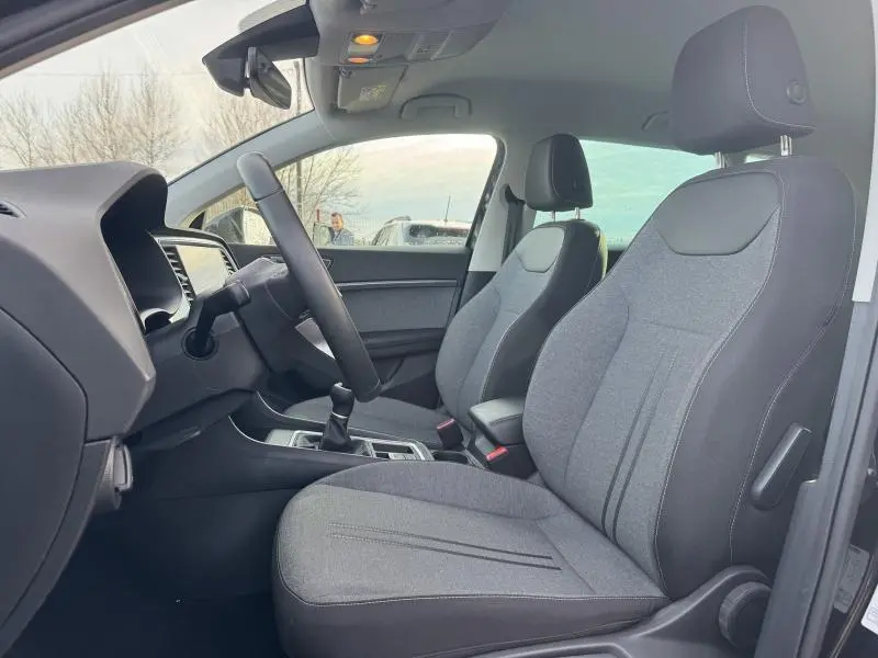 Vue intérieure côté conducteur du SEAT Ateca 2024, sièges en textile gris Dallas/Olot et volant cuir multifonction.