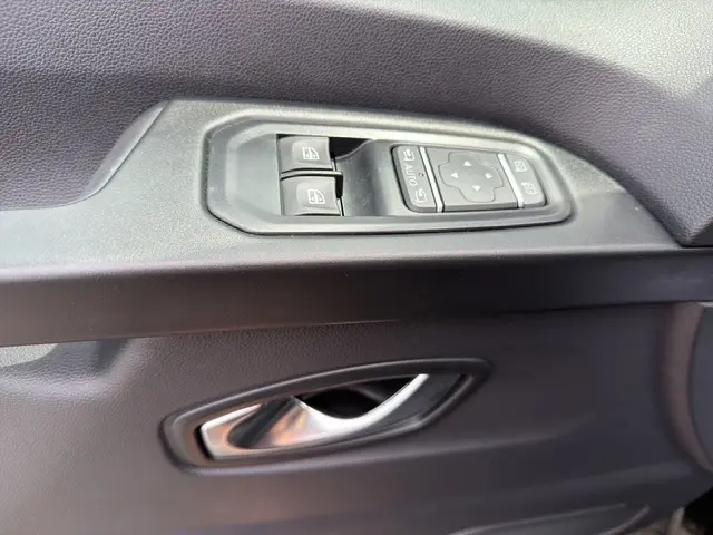 Détail de la porte intérieure côté conducteur du Nissan Primastar noir, avec commandes des vitres et rétroviseurs électriques.