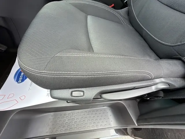 Gros plan sur le siège avant droit en tissu noir du Nissan Primastar 2025, avec réglage manuel visible.