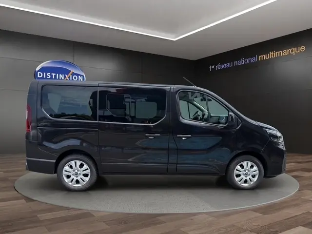Profil droit d’un Nissan Primastar noir 2025, version Tekna, avec portes latérales vitrées et jantes argentées.