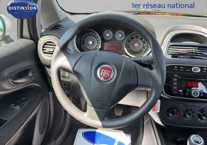 Vue intérieure centrée sur le volant Fiat d'une Punto Street 2016, avec tableau de bord et commandes visibles.