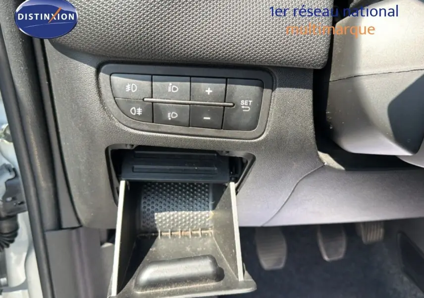 Gros plan sur le tableau de bord côté gauche d'une Fiat Punto Street gris argent de 2016 avec commandes d'éclairage et cendrier ouvert.