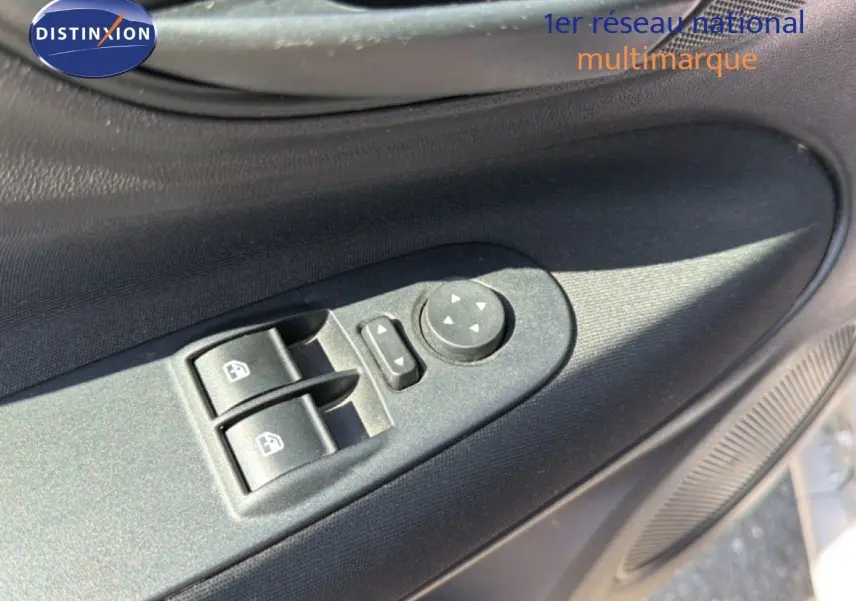 Gros plan sur les commandes électriques des vitres et rétroviseurs côté conducteur d'une Fiat Punto gris argent 2016.