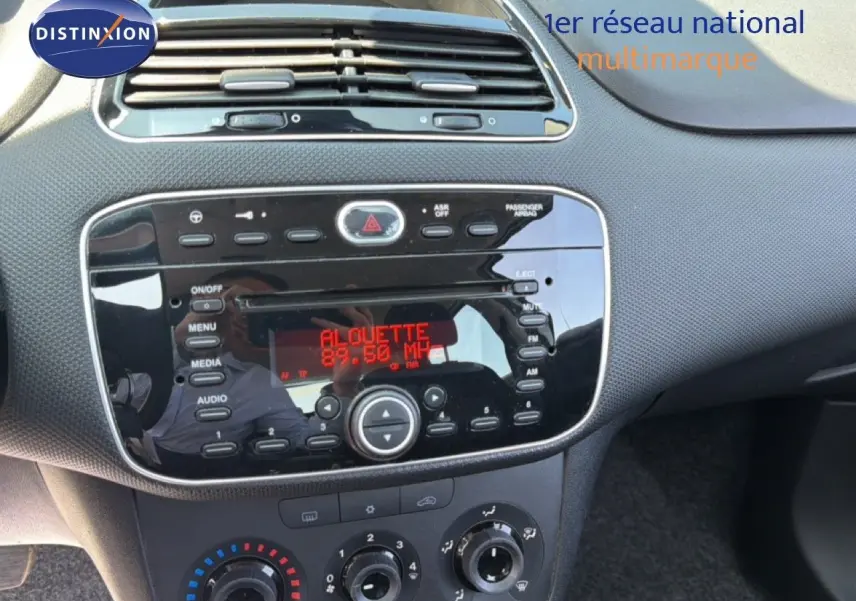 Vue rapprochée du tableau de bord noir et gris argent de la Fiat Punto Street 2016 avec radio affichant la fréquence FM.