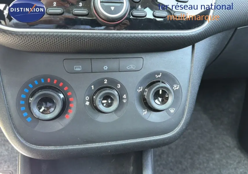 Vue rapprochée des commandes de climatisation d'une Fiat Punto Street gris argent de 2016, avec réglages manuels.
