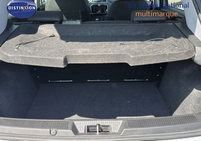 Vue intérieure du coffre ouvert d'une Fiat Punto Street gris argent de 2016, montrant la plage arrière et l'habitacle.