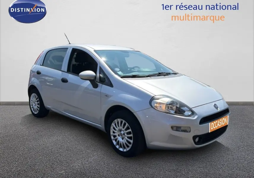 Fiat Punto Street gris argent vue 3/4 avant droit, compacte 5 portes avec jantes alliage et phares allumés.