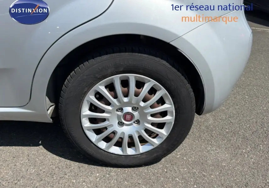 Gros plan sur la roue arrière droite gris argent d'une Fiat Punto Street 2016 avec jante alliage caractéristique.
