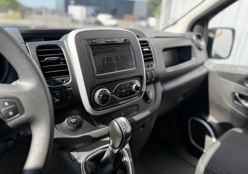 Vue intérieure côté conducteur du tableau de bord gris avec écran tactile et levier de vitesses automatique Renault Trafic 2021.