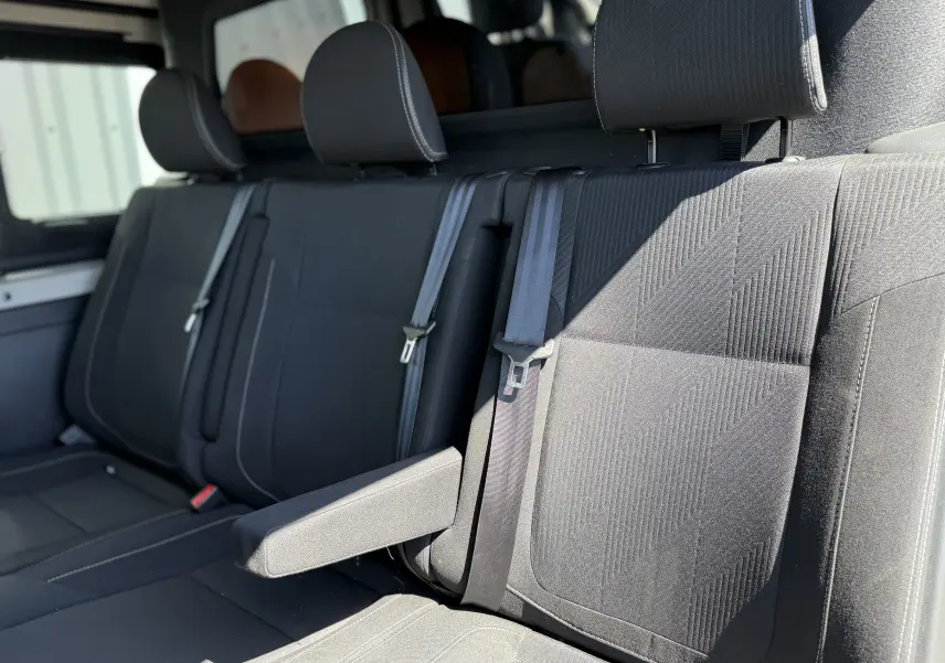 Vue intérieure rapprochée des sièges arrière noirs du Renault Trafic Cabine Approfondie 2021, avec appuie-bras déployé.