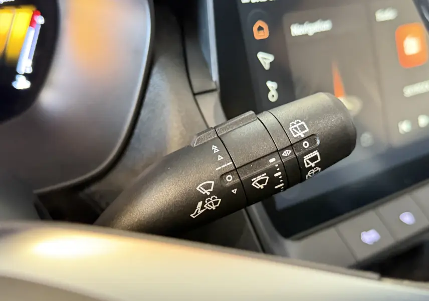 Gros plan sur la commande des essuie-glaces du MG ZS 1.5 L Hybrid+ 2026 avec écran tactile en arrière-plan.
