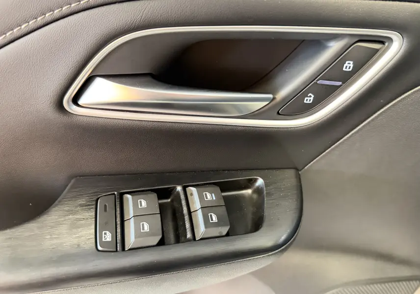 Gros plan sur la poignée intérieure et les commandes des vitres côté conducteur du MG ZS 1.5 L Hybrid+ 2026 en finition Luxury.