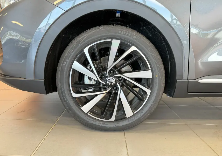 Gros plan sur la roue avant gauche du MG ZS Candem Grey avec jante alliage bicolore 18 pouces.