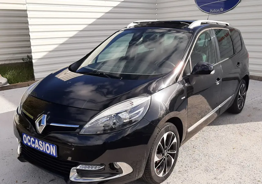 Renault Grand Scénic noir en 3/4 avant droit, avec jantes alliage bicolores et toit ouvrant visible.