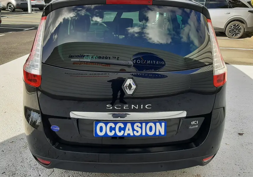 Vue arrière d'un Renault Grand Scenic noir 2015 avec badge dCi et plaque "OCCASION" sur parking extérieur.