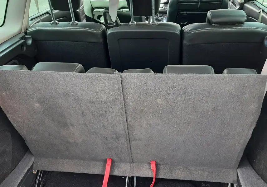 Vue arrière intérieure du Renault Grand Scenic noir 7 places, montrant les sièges rabattus et l'espace de coffre.