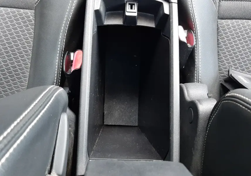 Vue plongeante sur le rangement central ouvert entre les sièges avant en tissu et cuir noir du Renault Grand Scenic DCI 110 Bose 7 places.