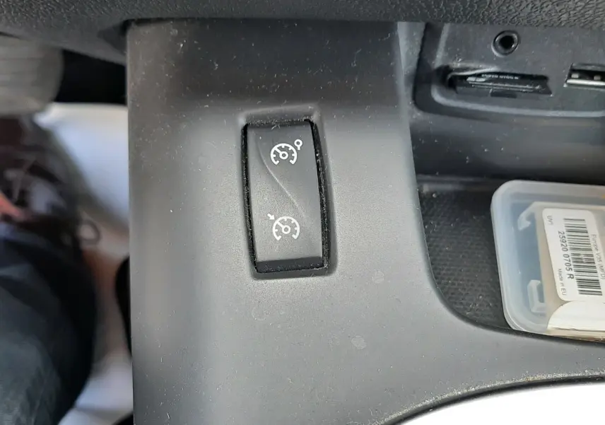 Gros plan sur le bouton de régulateur de vitesse dans l'habitacle noir du Renault Grand Scenic DCI 110 Bose 7 places.