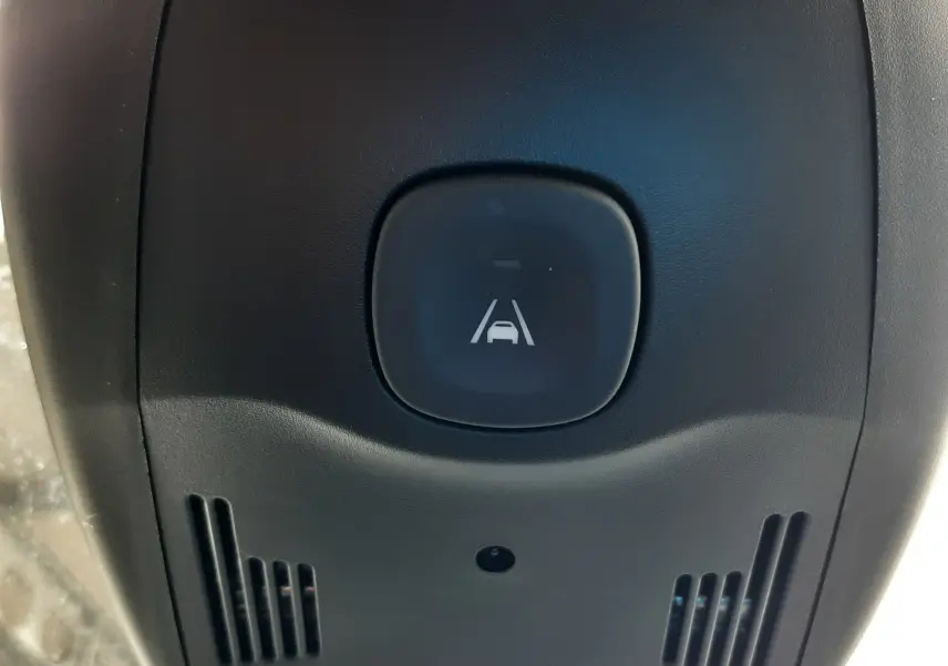 Gros plan sur le bouton d'alerte de franchissement de ligne dans l'habitacle du Renault Grand Scenic noir.