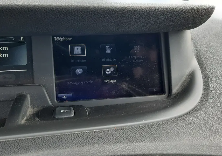 Vue rapprochée de l'écran tactile central du tableau de bord d'un Renault Grand Scenic noir, affichant le menu téléphone.
