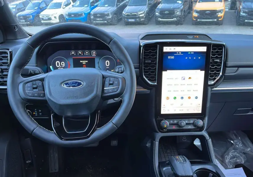 Vue intérieure du tableau de bord du Ford Ranger blanc glacier 2026, avec volant multifonctions et grand écran tactile vertical.