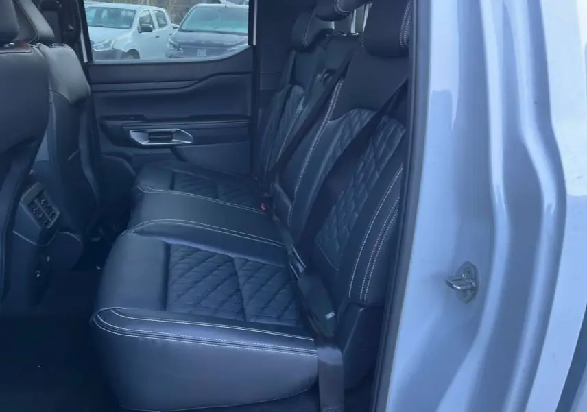 Vue intérieure côté droit sur les sièges arrière en cuir noir matelassé du Ford Ranger blanc glacier 2026.