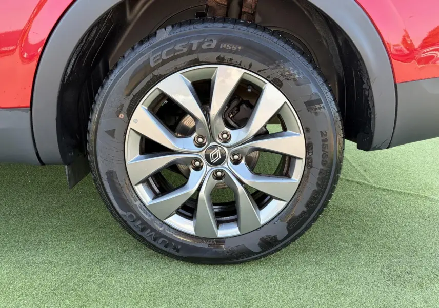 Gros plan sur la roue avant droite d’un Renault Arkana rouge flamme métal avec jante alliage grise 17 pouces Bahamas.