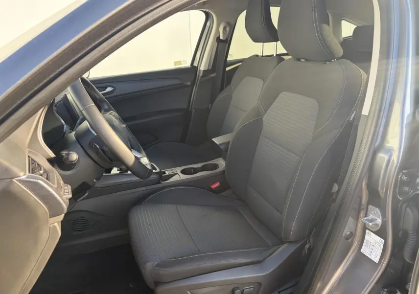 Vue intérieure côté conducteur de la Renault Arkana 2025, sièges noirs avec réglage électrique et accoudoir central.