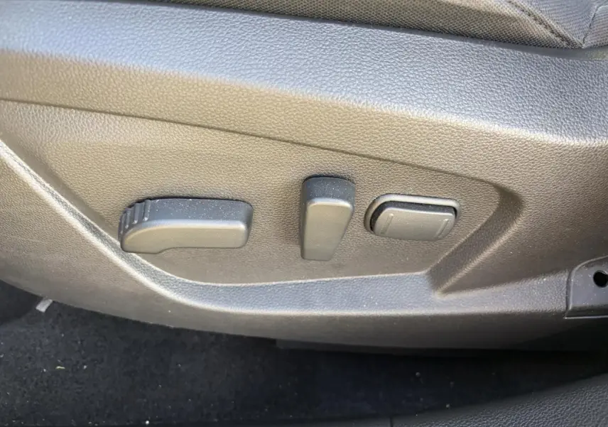 Gros plan sur les commandes de réglage électrique du siège conducteur du Renault Arkana 2025.