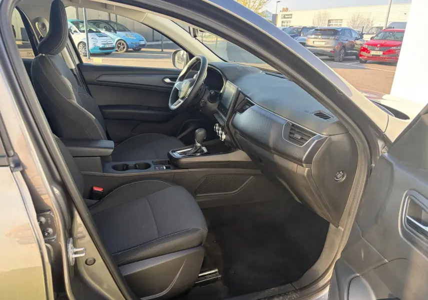 Vue intérieure côté conducteur du Renault Arkana 2025, montrant sièges noirs et tableau de bord moderne.