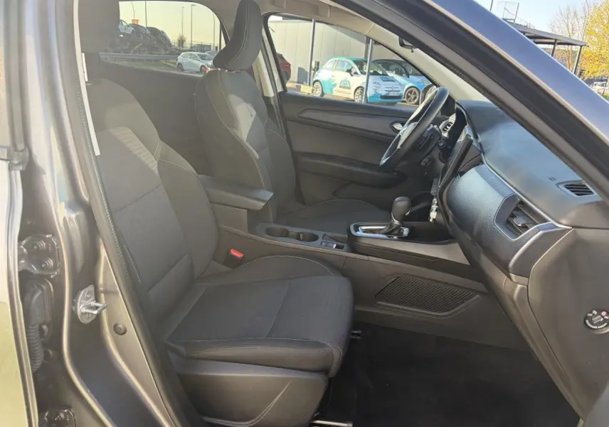 Vue intérieure côté conducteur de la Renault Arkana 2025, sièges noirs et console centrale avec boîte automatique.