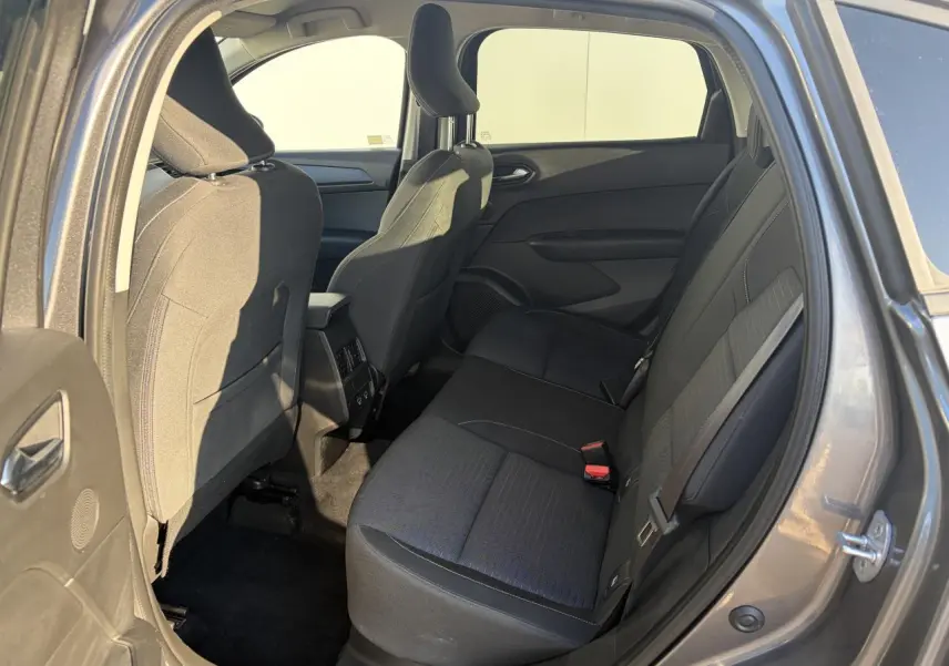 Vue intérieure arrière côté droit du Renault Arkana 2025, sièges tissu noirs et espace passagers visible.