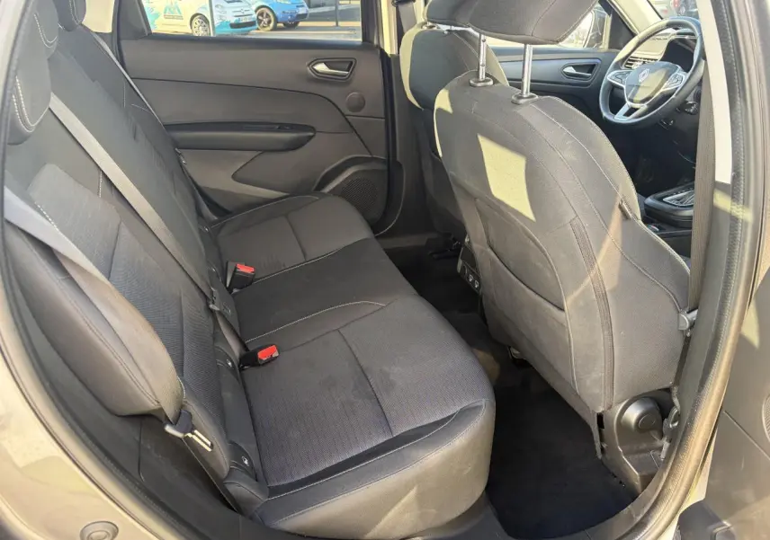 Vue intérieure arrière côté gauche montrant les sièges noirs et l'habitacle spacieux du Renault Arkana 2025.