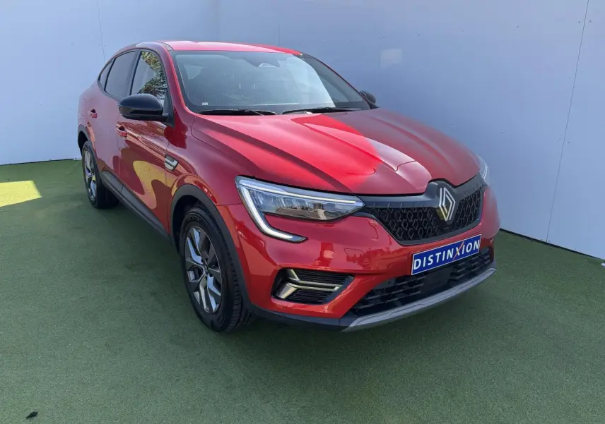 Renault Arkana rouge flamme métal vu en 3/4 avant droit, avec calandre noire et jantes alliage grises 17 pouces.