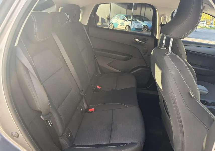 Vue intérieure arrière côté gauche de la Renault Arkana 2025, sièges tissu noirs avec surpiqûres blanches.