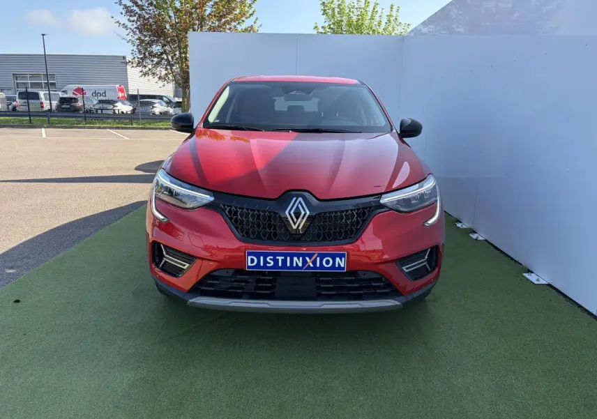 Vue de face du Renault Arkana 2025 rouge flamme métal avec calandre noire et logo Renault centré.