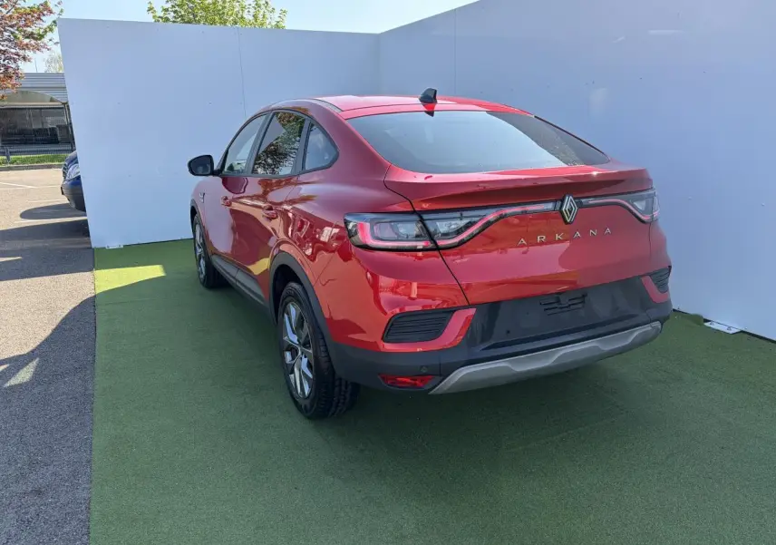 Vue 3/4 arrière droite d'un Renault Arkana rouge flamme métal, avec feux arrière LED et jantes alliage grises 17 pouces.