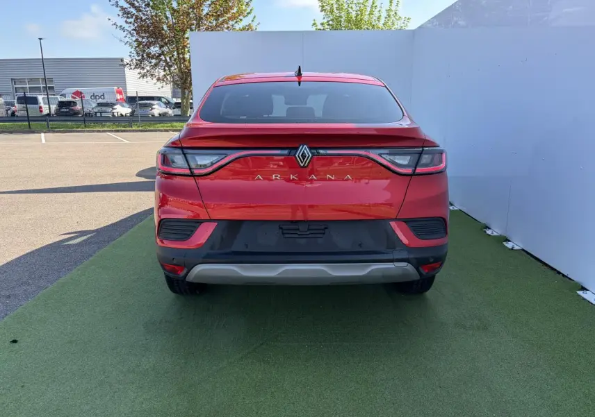Vue arrière d'une Renault Arkana rouge flamme métal 2025 avec feux LED reliés et lunette arrière surteintée.