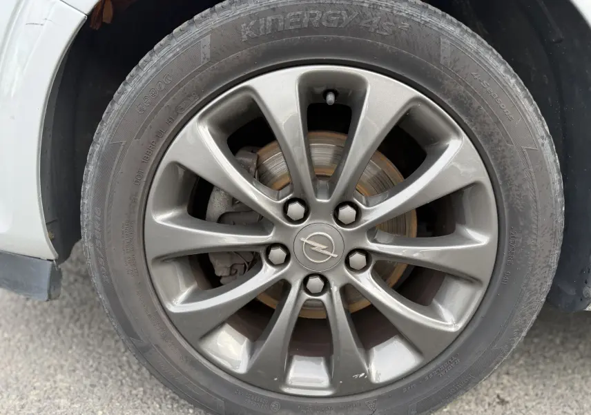 Gros plan sur la jante gris foncé de 17 pouces avec logo Opel au centre, montée sur un pneu 205/55 R16.