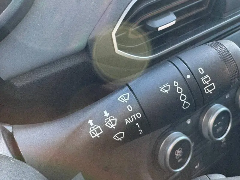 Gros plan sur la commande des essuie-glaces du Dacia Jogger 2024, intérieur noir avec détails argentés.