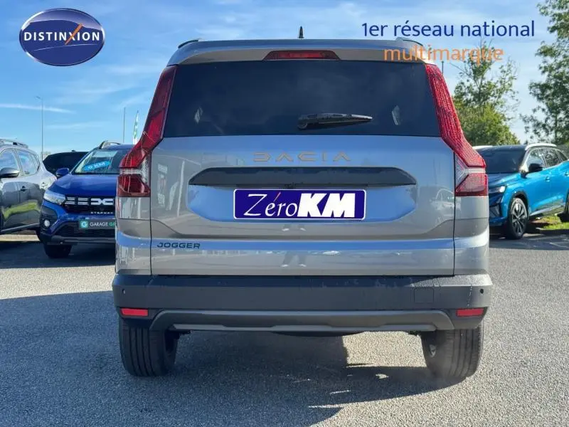 Vue arrière d'un Dacia Jogger gris schiste métallisé avec feux arrière verticaux et plaque Zéro KM visible.