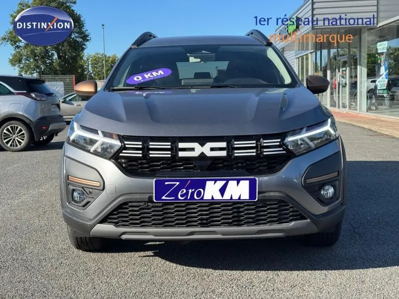 Vue avant d'un Dacia Jogger gris schiste métallisé avec calandre noire et phares LED allumés.